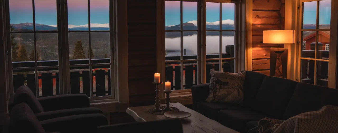 en stue med utsikt over innsjø og fjell