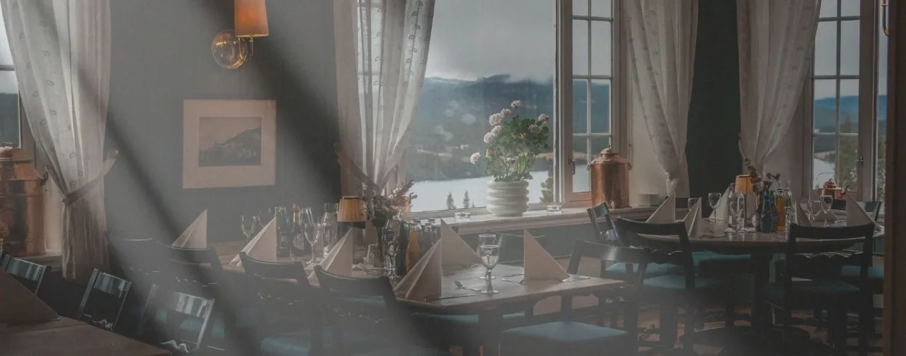 et rom med bord og stoler og et vindu