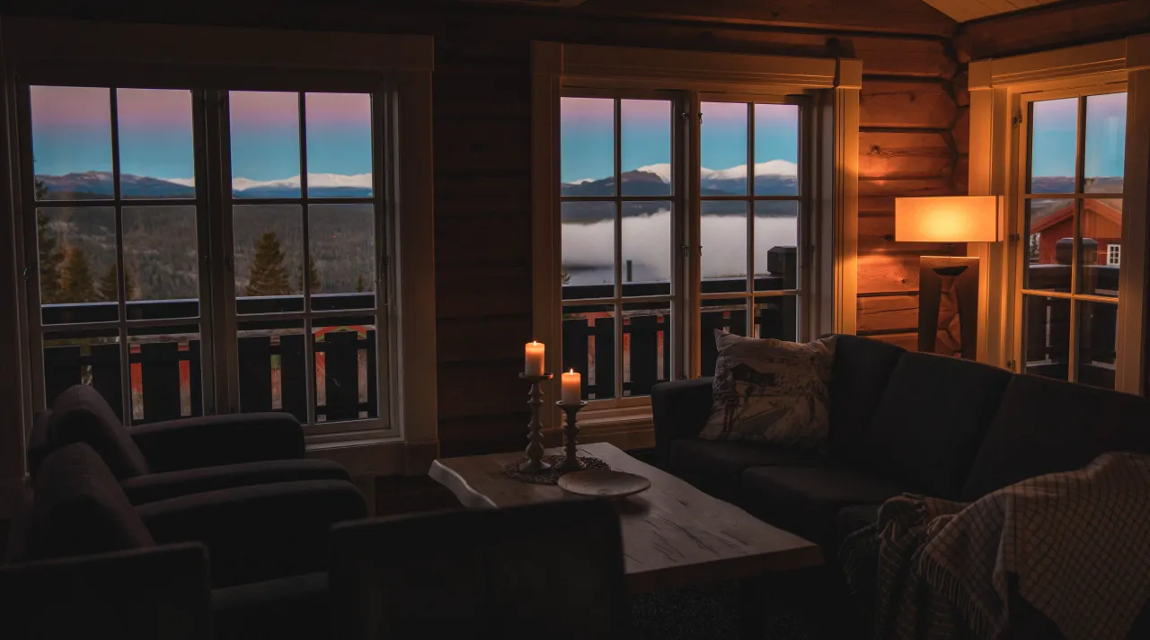 en stue med utsikt over innsjø og fjell