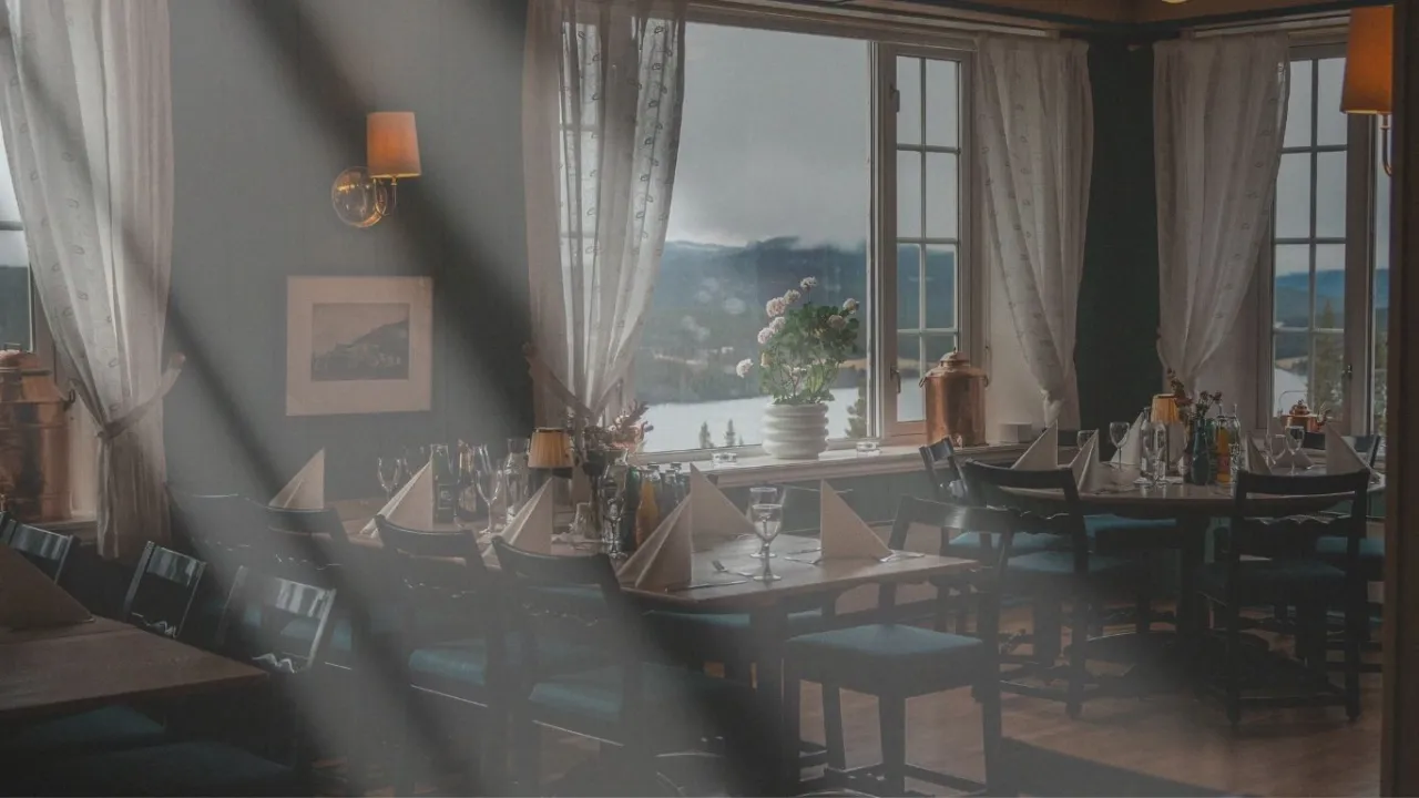 et rom med bord og stoler og et vindu