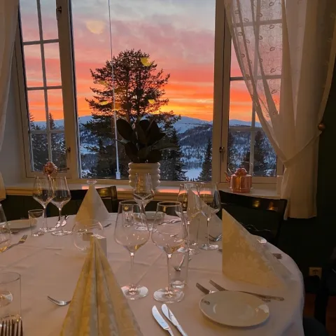 Et bord dekket til middag med utsikt over solnedgangen