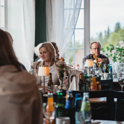 en gruppe mennesker som sitter ved bord